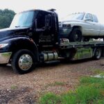 Big Mike’s Wrecker Service flatbed tow truck hauling a white pickup in Palestine TX