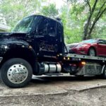 Big Mike’s Wrecker Service flatbed tow truck hauling a red sedan in Palestine TX