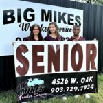 High school seniors posing with Big Mike’s Wrecker Service banner in Palestine Texas