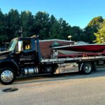 Flatbed tow truck from Big Mike’s Wrecker Service hauling bass boat in Palestine TX