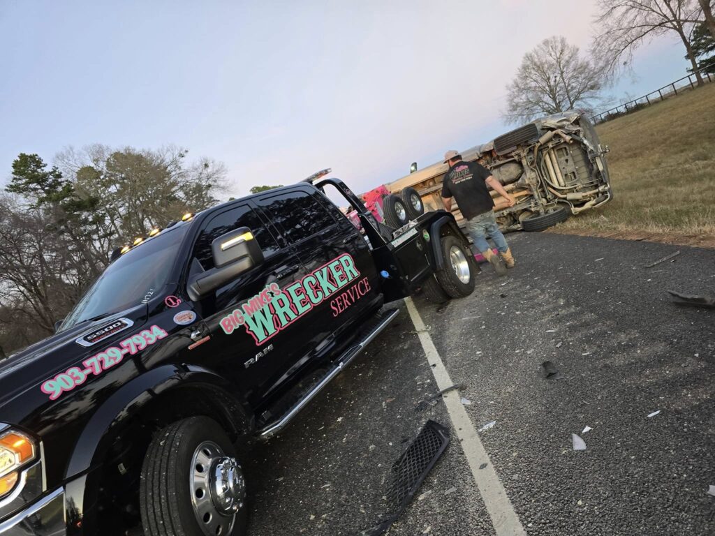 Big Mike’s Wrecker Service performing accident recovery for overturned SUV on roadside