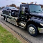 Damaged sedan loaded on Big Mike’s Wrecker Service flatbed tow truck