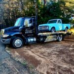 Big Mike’s Wrecker Service flatbed tow truck transporting a classic Chevy pickup in Palestine TX