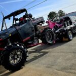 Big Mike’s Wrecker Service hauling Polaris Ranger 1000 XP UTV on pink wheel lift tow truck