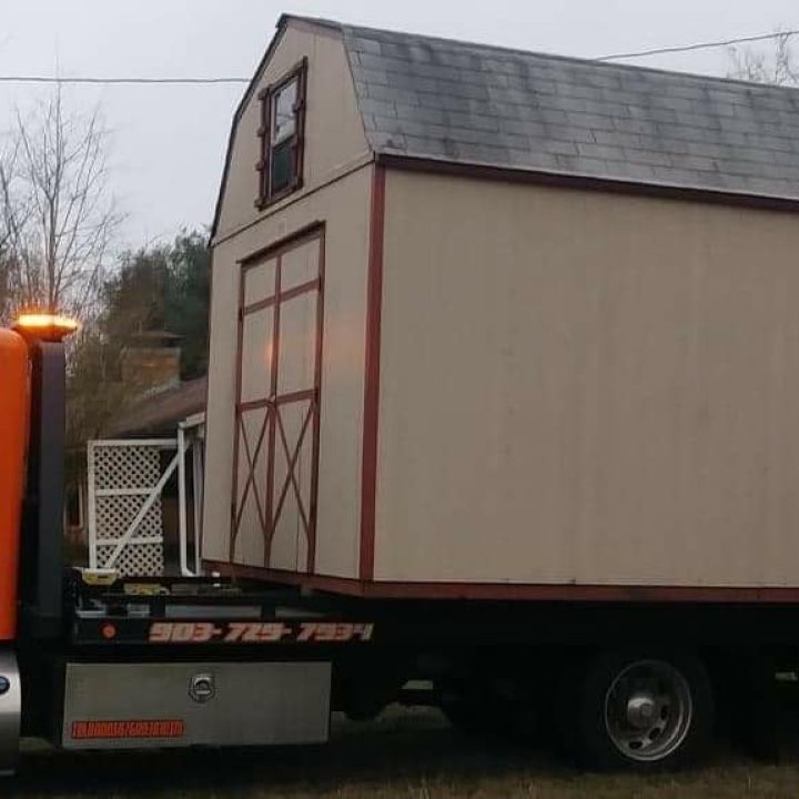 Big Mike’s Wrecker Service flatbed tow truck transporting a storage shed in Palestine TX